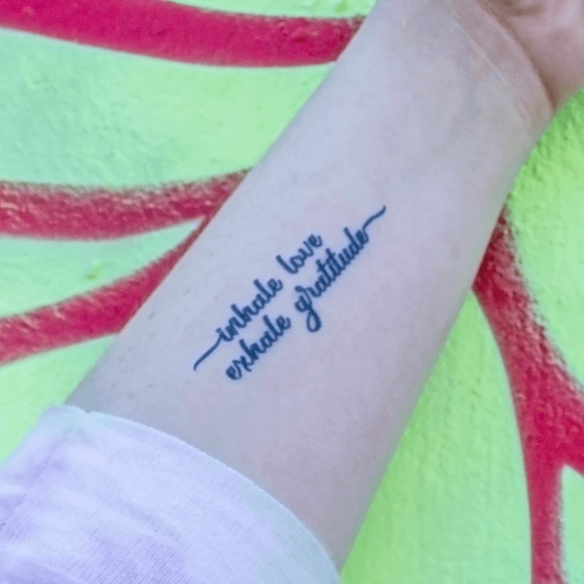 Gratitude” tattoo on the wrist.